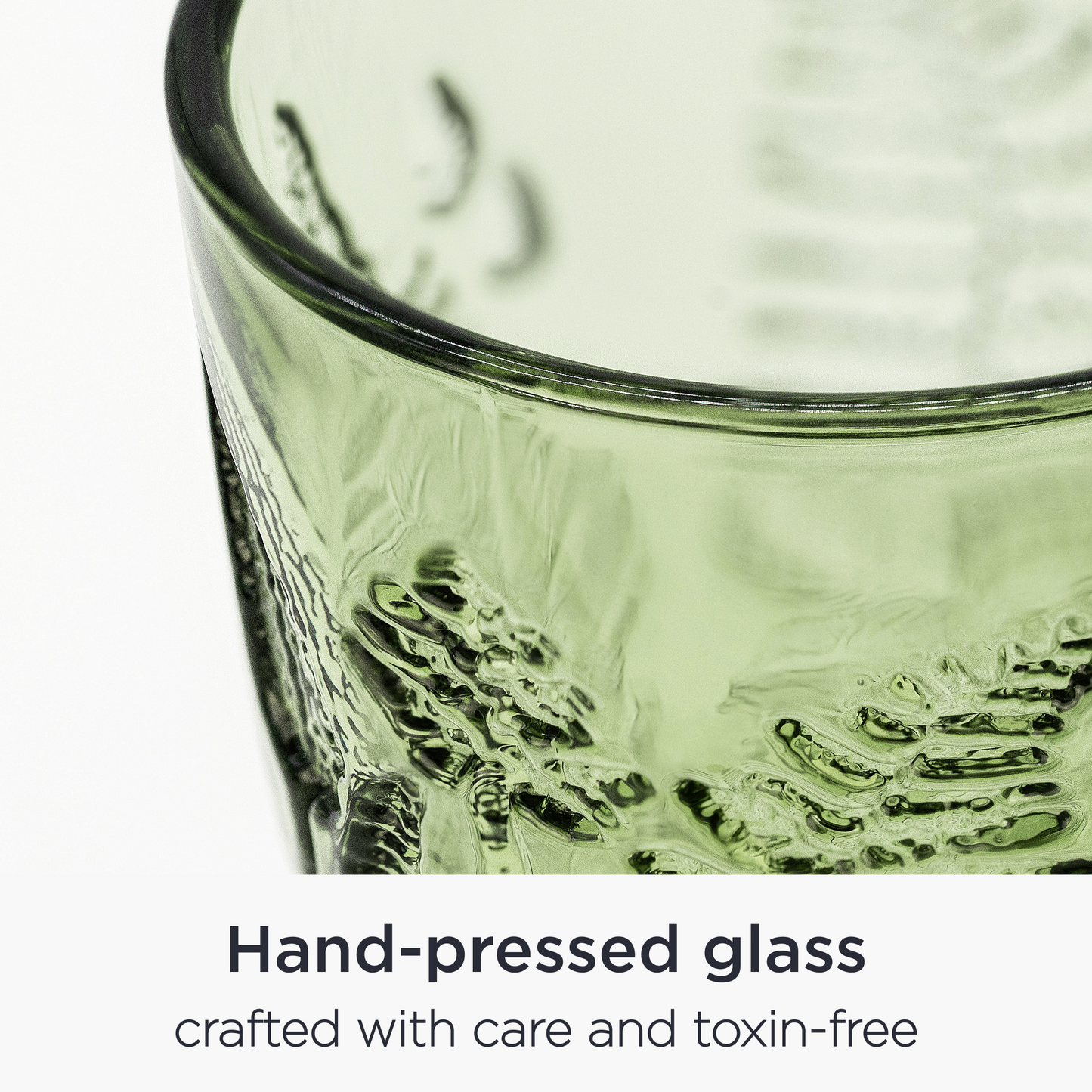 Close-up of embossed fern leaf pattern on green glass goblet