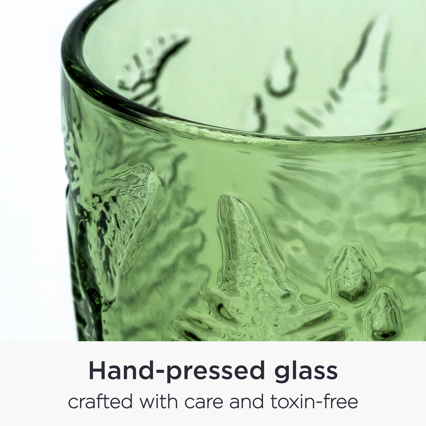 Close-up of embossed fern leaf pattern on vintage green glass surface