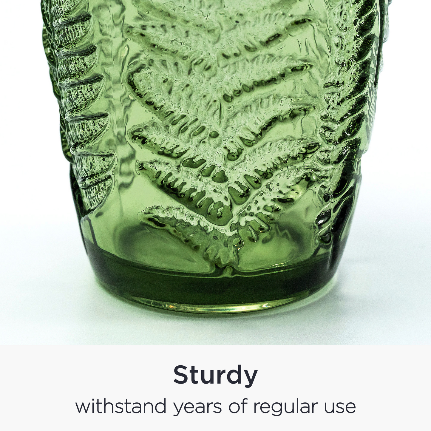 Close-up of embossed fern leaf pattern on vintage green glass surface