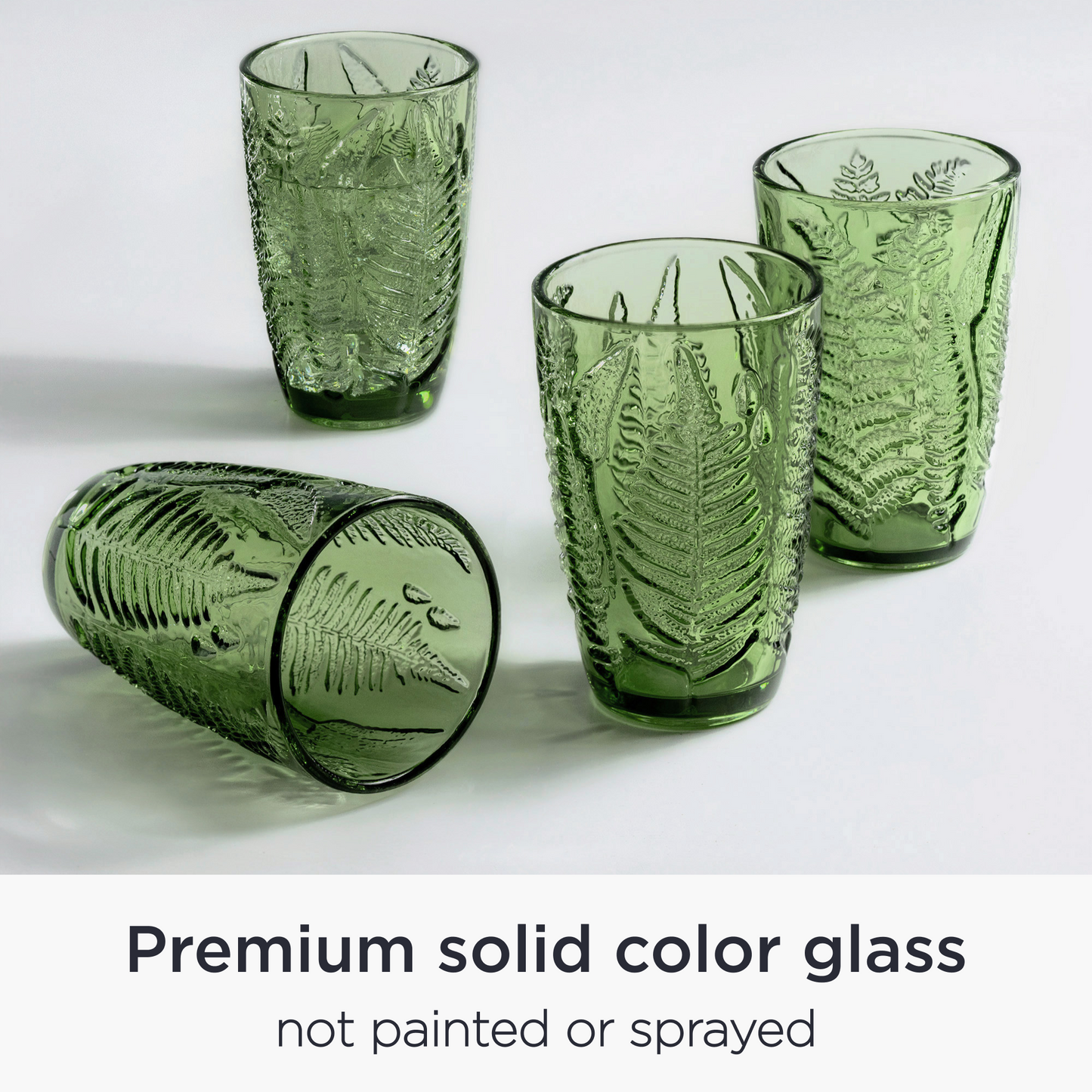 Angled view of four hand-blown green vintage glasses with textured glassware design