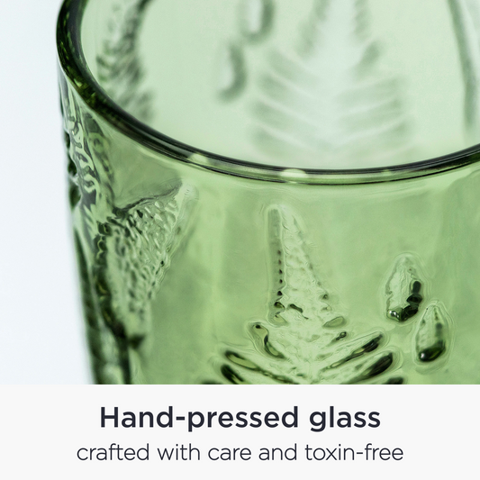 Close-up of embossed fern leaf pattern on vintage green glass surface