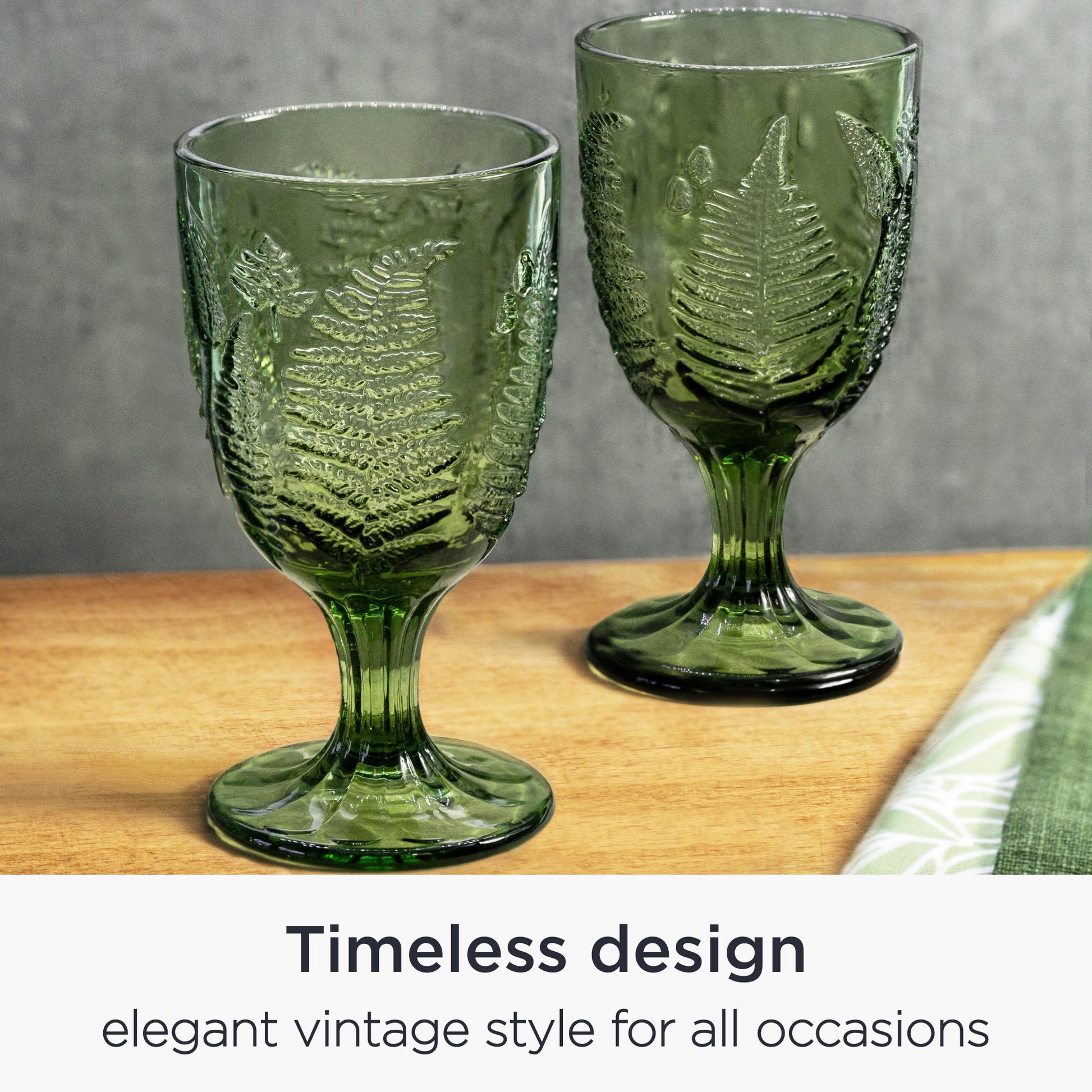 Hand-blown green goblets styled on a wooden dining table